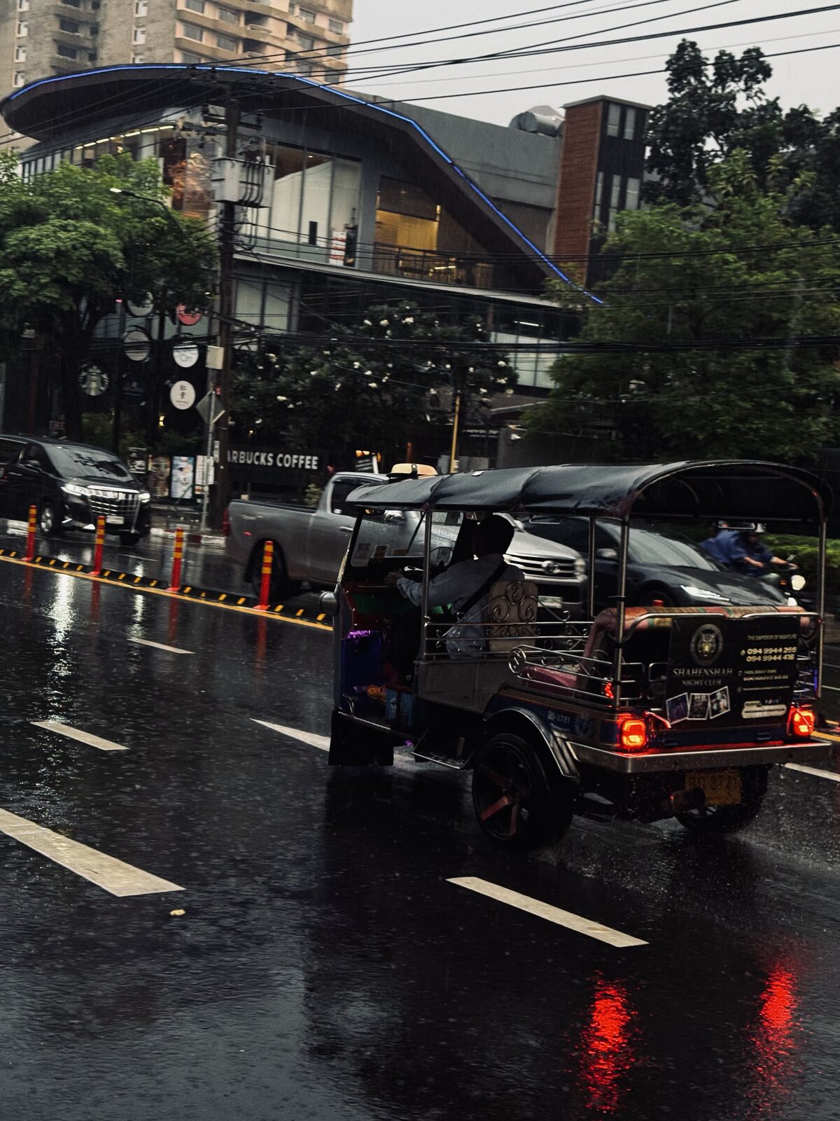 A tuk-tuk in the rain on a Bangkok street